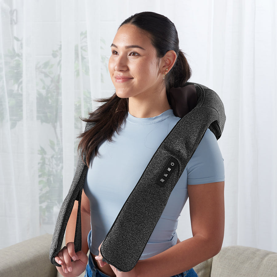 A woman wearing a grey neck and shoulder massager